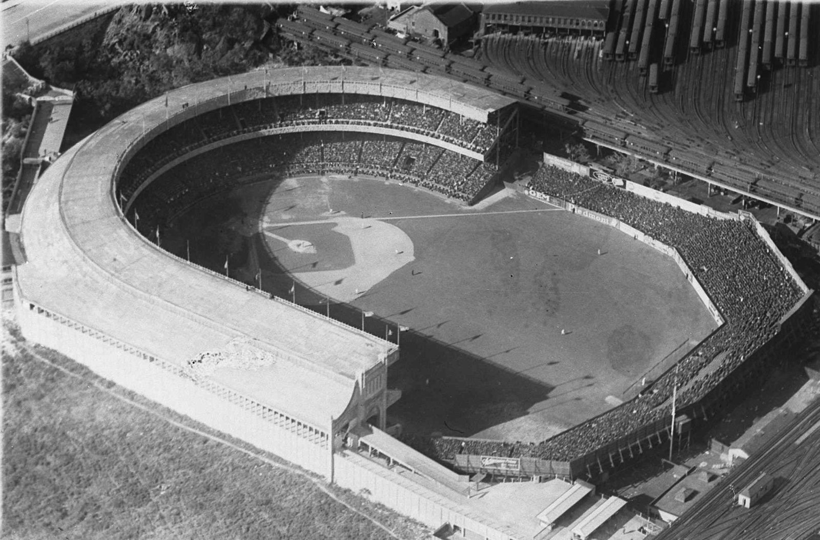 Aerial photograph of the Polo Grounds in 1921, with rows of elevated railway cars parked in the storage yard fanning out behind the grandstand.
