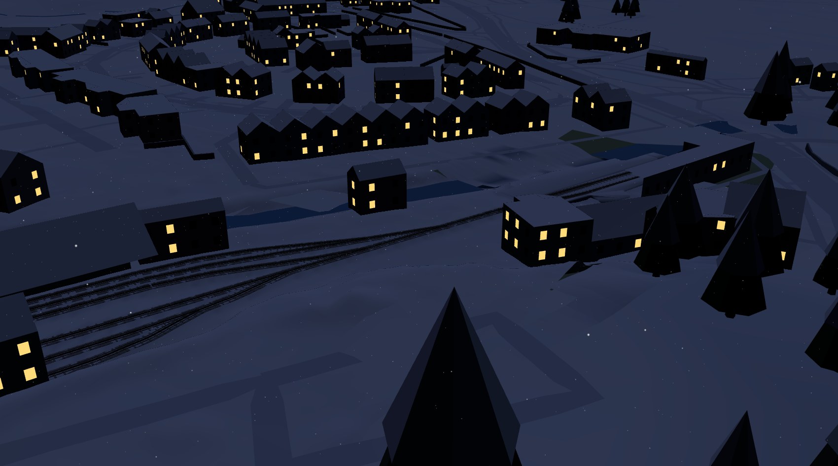 Llanberis on a winter night, the station tracks under snow and lights in the windows of the village